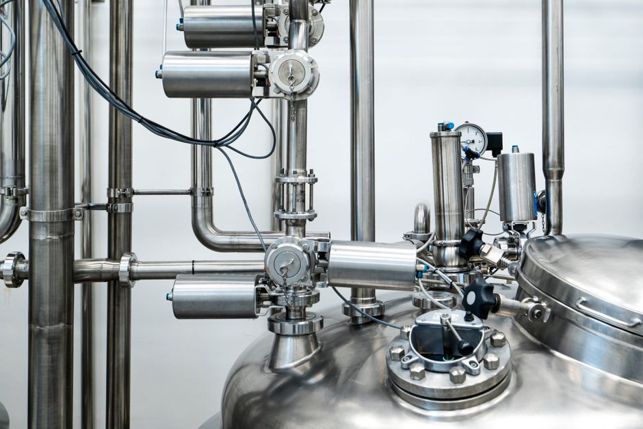 Close-up of stainless steel machinery and pipes in an industrial setting, showcasing modern engineering. (Photo: Policarpo Brito / Pexels)