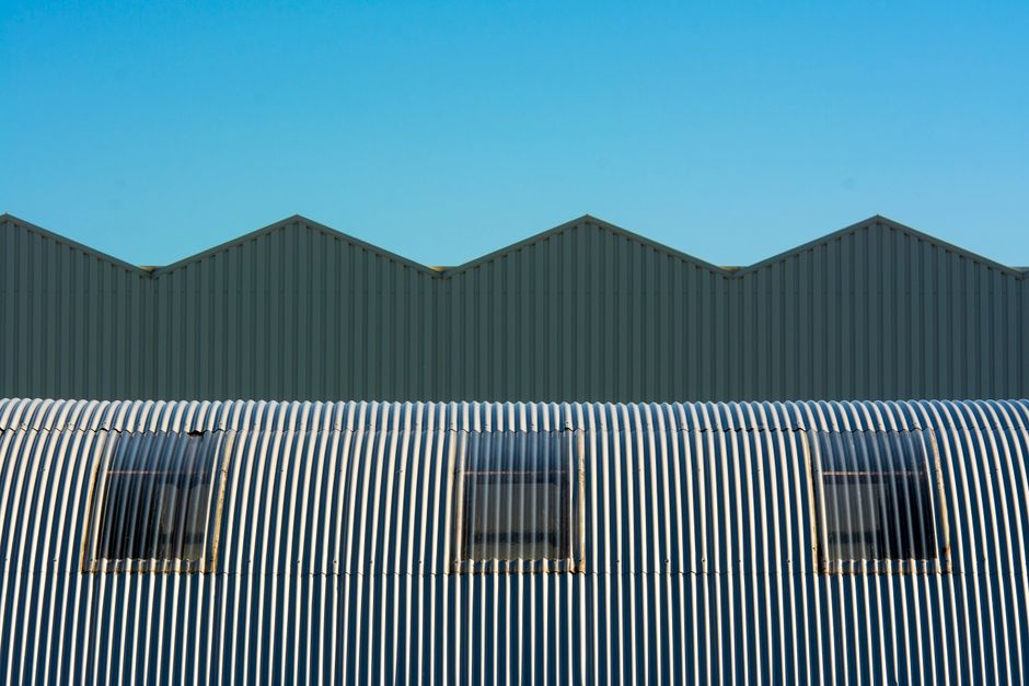 Industrial warehouse with corrugated and cylindrical roof design showcasing geometric structure. (Photo: Jan van der Wolf / Pexels)
