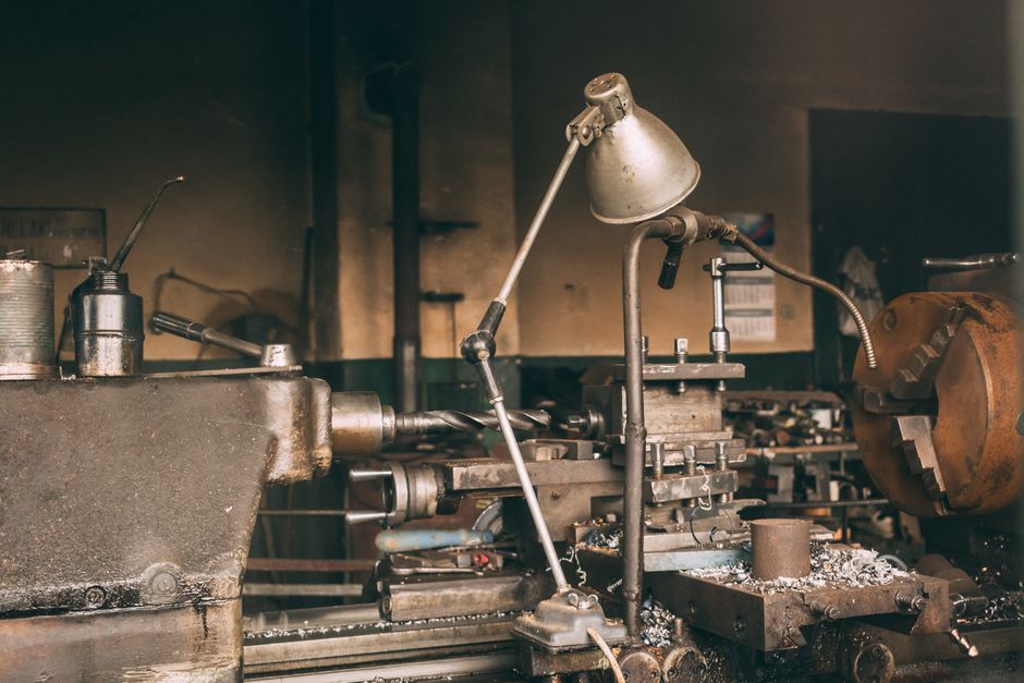 A rusty industrial lathe in a vintage workshop setting showcasing metalwork machinery. (Photo: Marian Cosnete / Pexels)