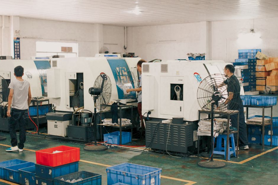 Workers operating machinery in an industrial factory setting, showcasing manual labor and production. (Photo: Mehmet Turgut Kirkgoz / Pexels)