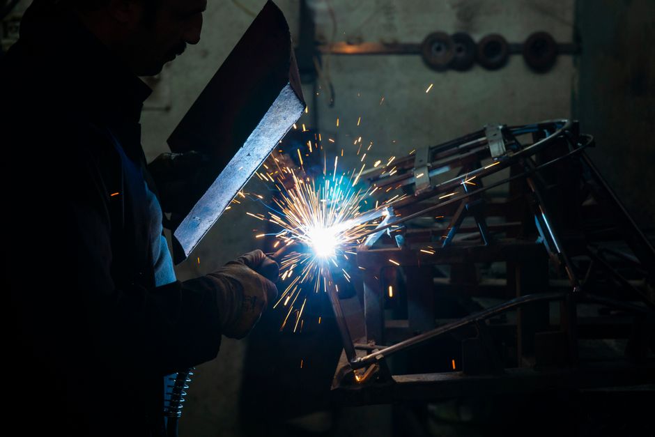 A skilled welder uses a torch to work on metal in an industrial workshop setting. (Photo: Engin Akyurt / Pexels)